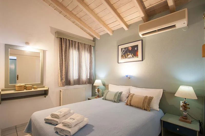 A double bed under the sloping wooden ceiling