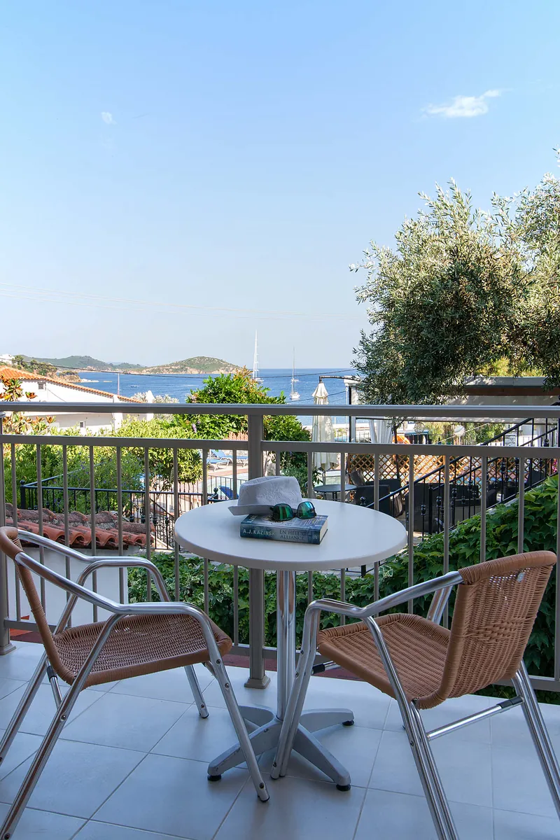 Καρέκλες και τραπέζι στο μπαλκόνι, με τη θάλασσα πιο πέρα