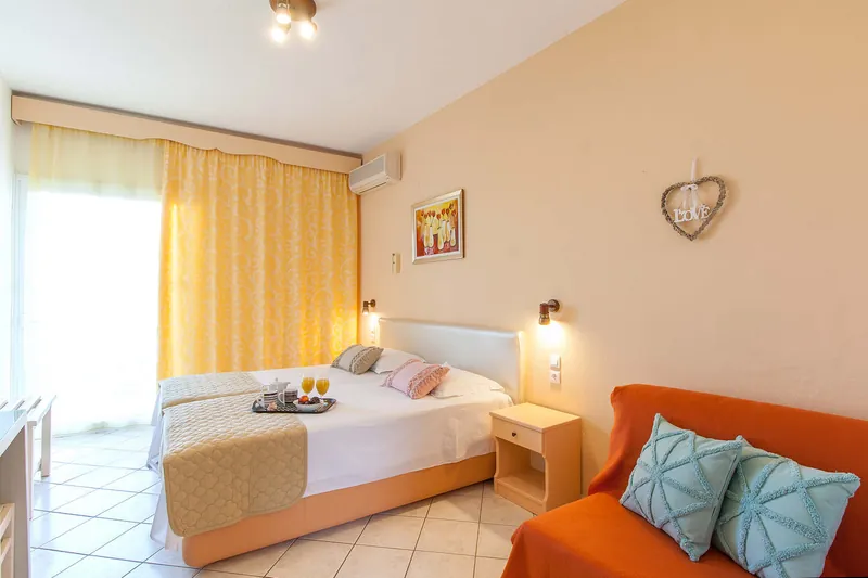 Twin beds and an orange sofa in a studio